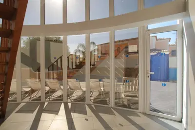 a room with sliding glass doors and a table and chairs at Full private 300sqm Villa Jacuzzi Heated Pool Ideal & quiet location in Albufeira