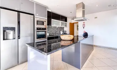 a kitchen with a black counter top and a refrigerator at Full private 300sqm Villa Jacuzzi Heated Pool Ideal & quiet location in Albufeira