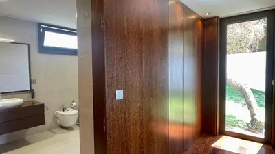 a bathroom with a wooden door with a toilet and a window at Passion by Check-in Portugal in Albufeira