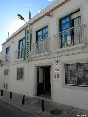 a white building with a sign on the side of it at Hotel Adelaide in Faro