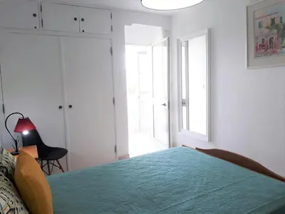 a bedroom with a bed with a blue bedspread at Sol europa- Vista Mar, 150mt Praia, Wifi in Quarteira