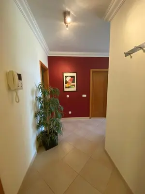 a hallway with a plant and a red wall at Apartamento Vista Golfe Mar Vilamoura in Vilamoura