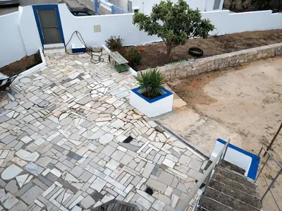 a stone patio with a potted plant on it at Sleep & Go Faro Airport Guest House in Faro