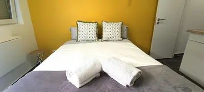 a bedroom with a large bed with white sheets and pillows at Sleep & Go Faro Airport Guest House in Faro
