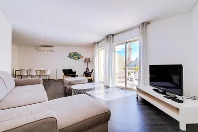 a living room with a couch and a flat screen tv at AL - Apartamento Terracos da Falesia in Vilamoura