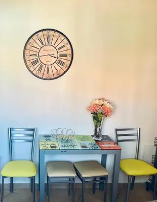 a table with four chairs and a clock on the wall at Albufeira Villa Santa Maria in Albufeira