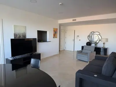 a bedroom with a bed with a television and a table at VilamouraSun Aquamar 518 - Fantástico Vista in Vilamoura