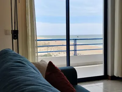 a living room with a view of the beach at Oceanides Beachfront Apartments in Quarteira