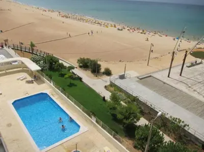 an overhead view of a beach with a swimming pool at Oceanides Beachfront Apartments in Quarteira