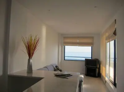 a living room with a table and a television at Oceanides Beachfront Apartments in Quarteira