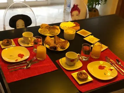 a black table with plates of food and cups of coffee at Villa Monaco in Faro