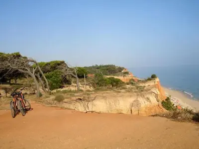 a bike parked on a beach next to the ocean at Amendoeiras I - Central Vilamoura in Vilamoura