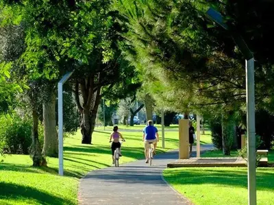 a man and a woman riding bikes down a path in a park at Amendoeiras I - Central Vilamoura in Vilamoura
