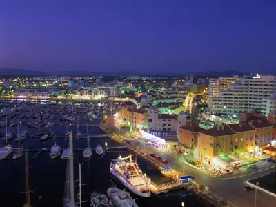 a city at night with boats in a harbor at Amendoeiras I - Central Vilamoura in Vilamoura