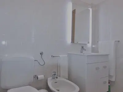 a white bathroom with a toilet and a sink at Amendoeiras I - Central Vilamoura in Vilamoura