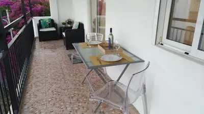 a glass table with a bottle of wine on it at Apt Cardoso 3 ao lado da Praia Peneco in Albufeira
