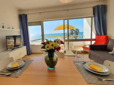 a living room with a table with a vase of flowers at T1 Praiamar 3 Vista Fabulosa in Quarteira