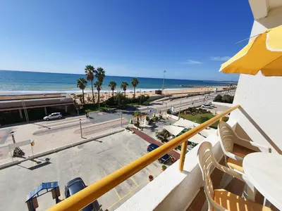 a balcony with a view of a beach and the ocean at T1 Praiamar 3 Vista Fabulosa in Quarteira