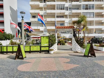 a building with flags and signs in front of it at T1 Praiamar 3 Vista Fabulosa in Quarteira