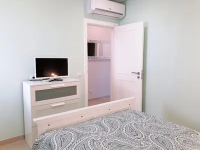 a bedroom with a tv on a dresser with a bed at T1 PraiaMar RC com Ar-Condicionado in Quarteira