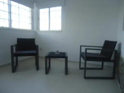two chairs and a table in a room with windows at VIVENDA L'OLIVIER in Quarteira
