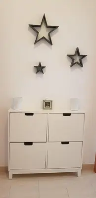 a white dresser with two stars on the wall at Apartamento T2 Encosta sao jose in Albufeira