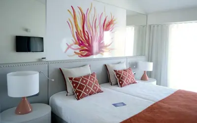 a bedroom with a bed with a fish painting on the wall at Quinta do Lago Country Club in Quinta do Lago