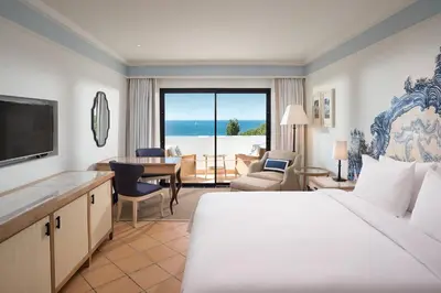 a hotel room with a bed and a view of the ocean at Pine Cliffs Hotel, a Luxury Collection Resort, Algarve in Albufeira