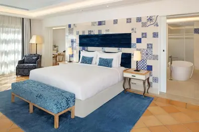 a bedroom with a large bed and a bathroom at Pine Cliffs Hotel, a Luxury Collection Resort, Algarve in Albufeira
