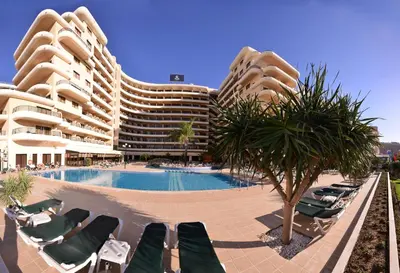 a large building with a swimming pool and lounge chairs at Vila Gale Marina in Vilamoura