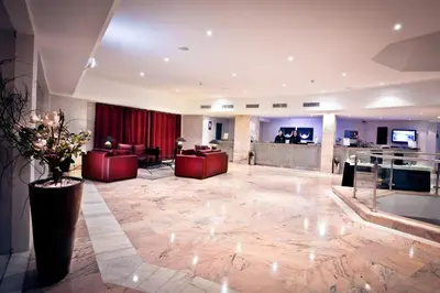 a hotel lobby with red chairs and a bar at Vila Gale Cerro Alagoa in Albufeira