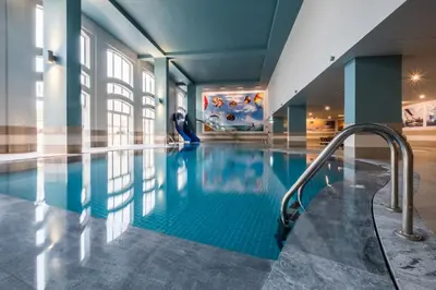 a pool in a building with a man standing next to it at Vila Gale Cerro Alagoa in Albufeira
