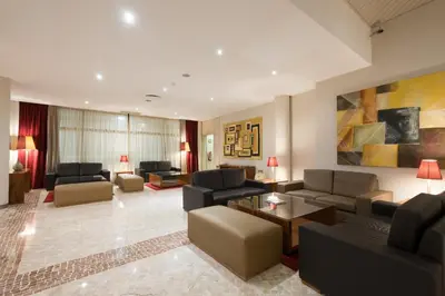 a living room with couches and chairs and a painting at Vila Gale Ampalius in Vilamoura