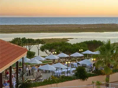 an aerial view of a beach with white umbrellas at Hotel Quinta do Lago in Quinta do Lago
