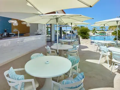 a restaurant with tables and chairs with umbrellas at Hotel Quinta do Lago in Quinta do Lago