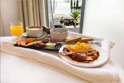 a breakfast plate of food and a glass of orange juice at Hotel Santa Eulália Bay in Albufeira