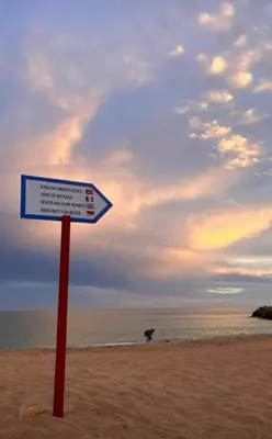 a sign on the beach with a dog in the background at Villa Ramos in Albufeira