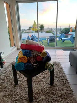 a pile of blankets sitting on a chair in a living room at Villa Ramos in Albufeira