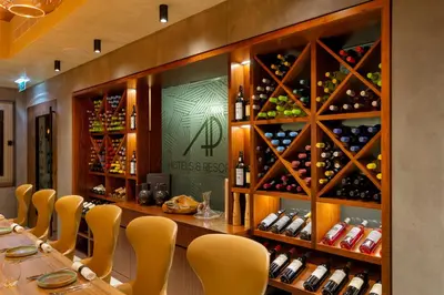 a restaurant with a long table with chairs and wine bottles at AP Eva Senses in Faro