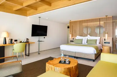 a hotel room with a large bed and a table at AP Eva Senses in Faro