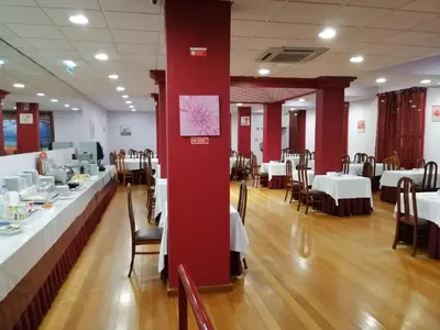 a dining room with tables and chairs and a window at Hotel Monaco in Faro