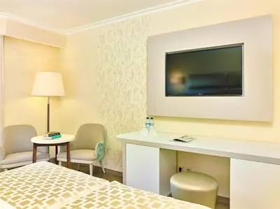 a hotel room with a bed and a flat screen tv at Hotel Baia Grande in Albufeira