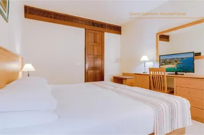 a bedroom with a bed and a desk with a computer at Auramar Beach Resort in Albufeira