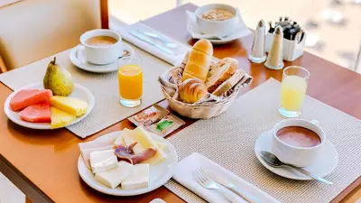 a table topped with plates of food and cups of coffee at Hotel Sol e Mar Albufeira - Adults Only in Albufeira