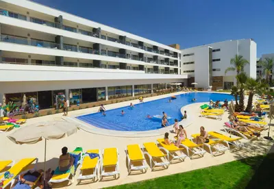 a pool with chairs and people in a hotel at Alfagar Alto da Colina in Albufeira