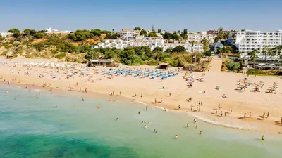 a bedroom with a bed and a desk and a television at Monica Isabel Beach Club in Albufeira