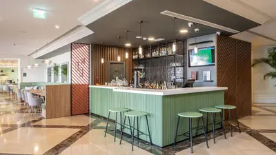 a restaurant with tables and chairs and windows at Holiday Inn Algarve Albufeira by IHG in Albufeira