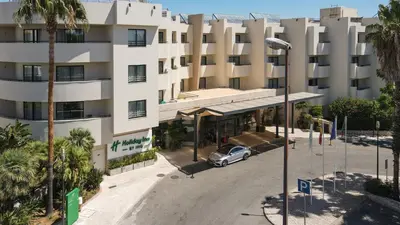 a lobby of a hospital with chairs and tables at Holiday Inn Algarve Albufeira by IHG in Albufeira