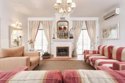 a living room with a couch and a fireplace at Martinhal Quinta Family Resort in Quinta do Lago
