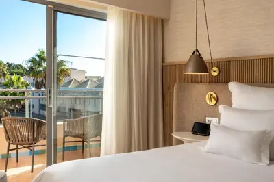 a bedroom with a large white bed and a desk at Grande Real Santa Eulalia Resort & Hotel Spa in Albufeira